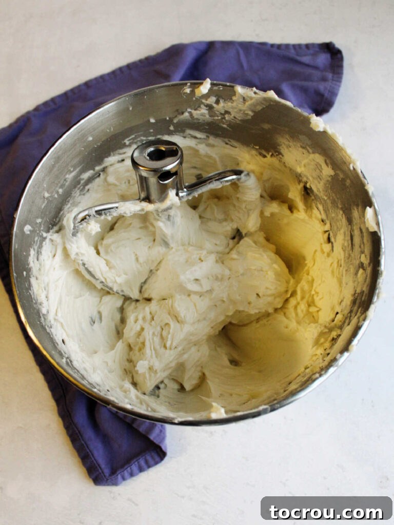 Mixer bowl filled with fluffy mock swill meringue buttercream and the paddle attachment.
