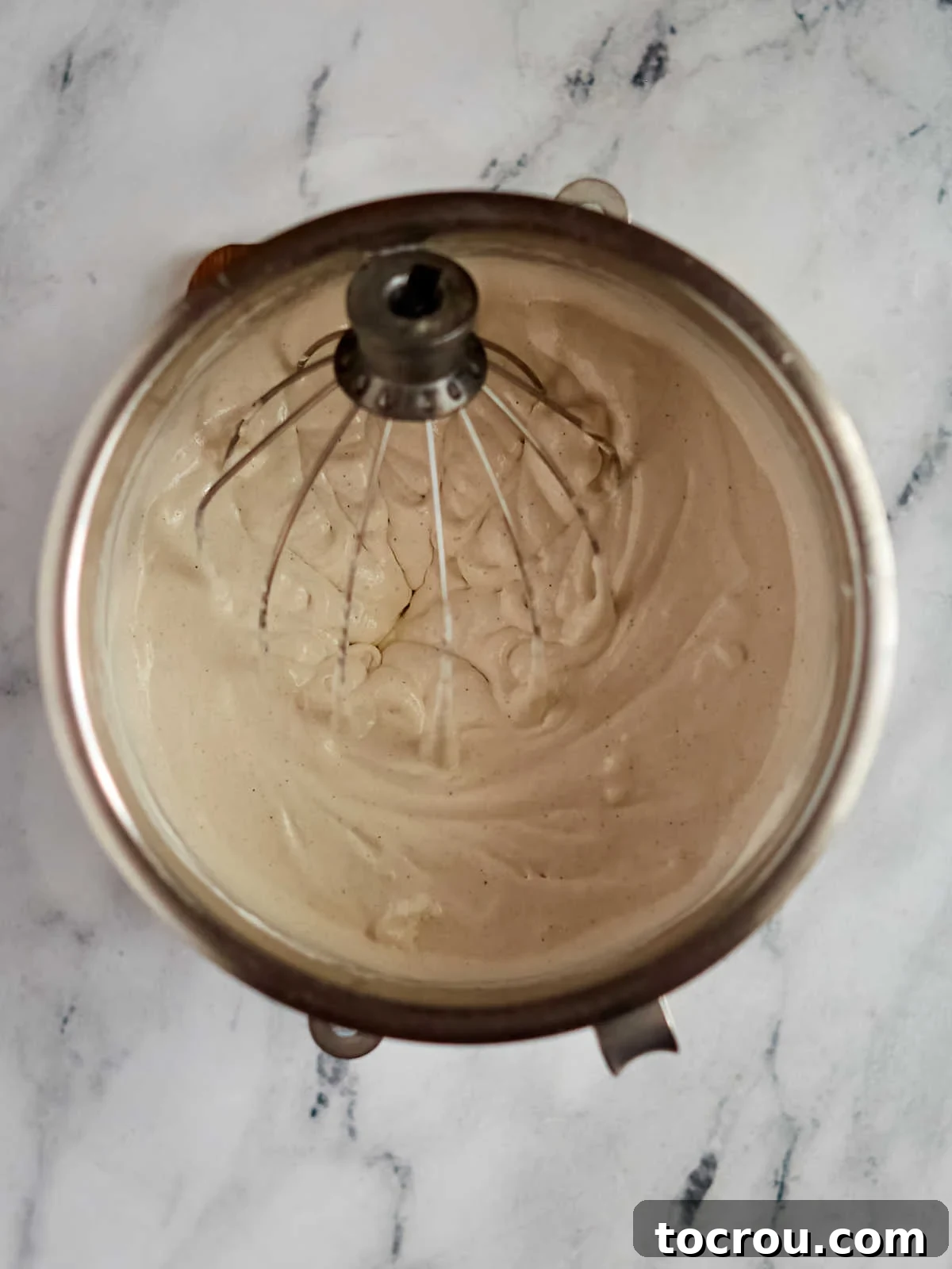 Ice cream, whipped topping, and cinnamon mixture in mixing bowl, ready to be put into pan between layers of cornflake mixture.