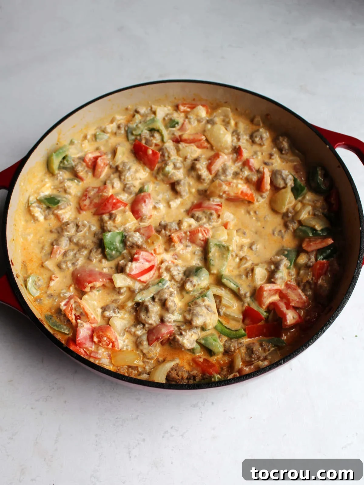 Creamy Chorizo Sauce A rich, cheesy, creamy sauce, studded with pieces of browned chorizo and colorful vegetables, simmers gently in a pan, ready for the addition of pasta.