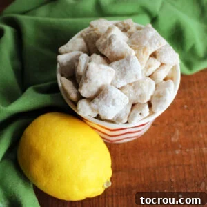 Small bowl of lemon puppy chow next to fresh lemon.