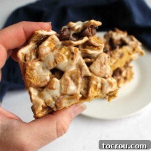 Hand holding a marshmallowy s'mores treat, ready to eat, showing its delicious texture.