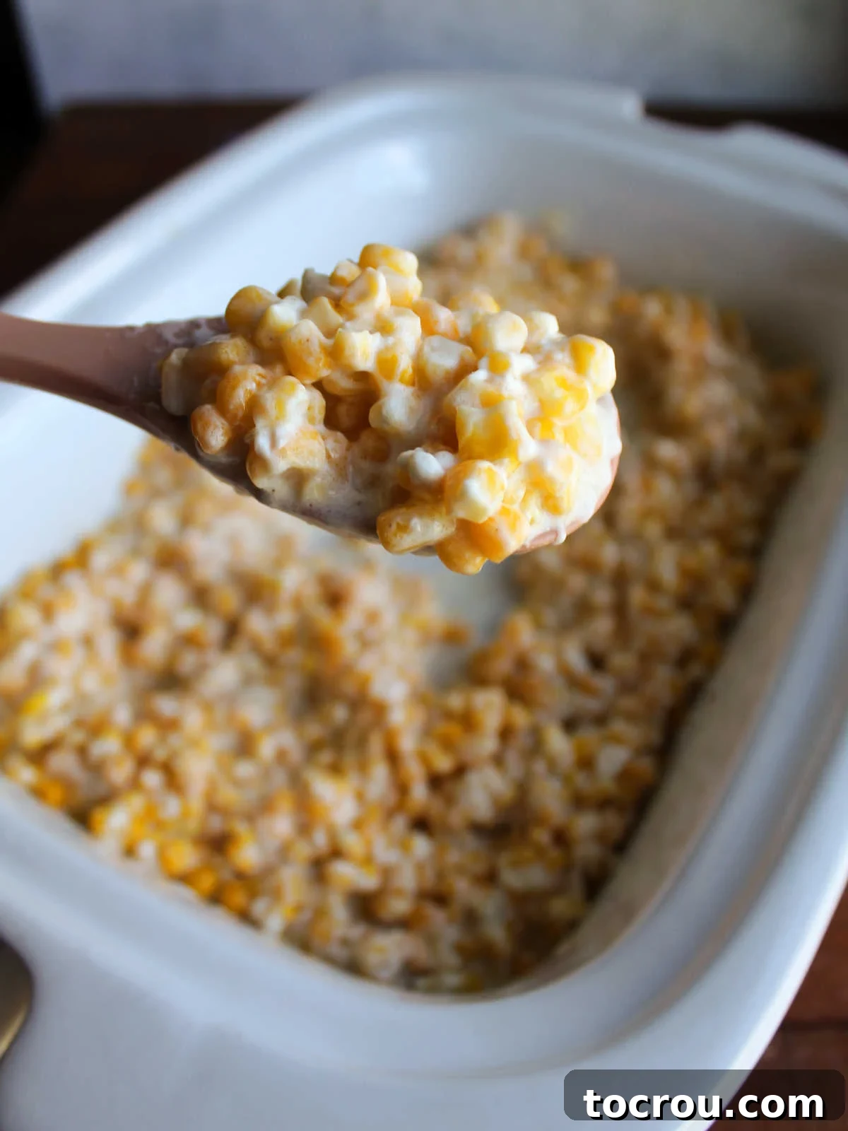 Close-up of Creamy Corn on a Serving Spoon A large spoon lifting a generous scoop of creamy corn, showcasing how each sweet kernel is beautifully coated in the rich, velvety sauce.