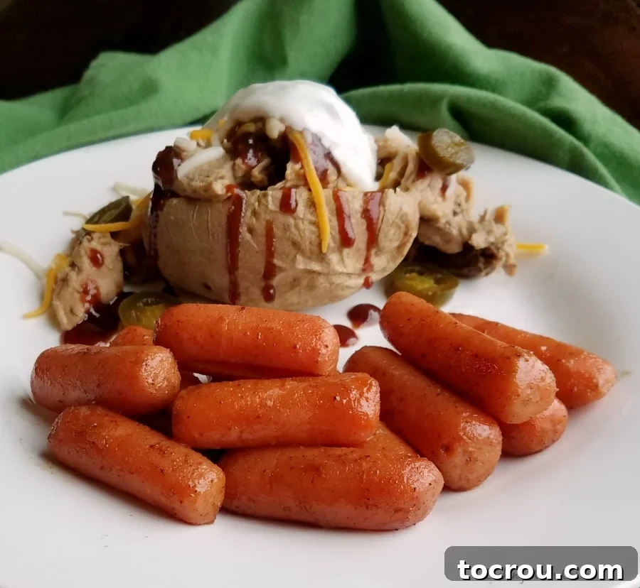 Delicious Honey Glazed Carrots paired with a savory meal. Honey glazed carrots served on a plate alongside pulled pork and a stuffed baked potato, showcasing their versatility.