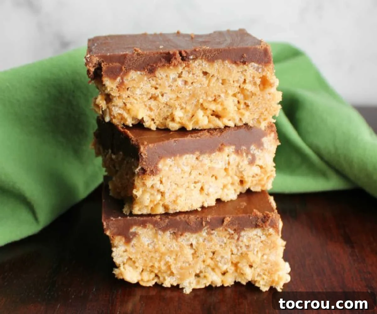 Stack of maple peanut butter rice krispie treats with fudge frosting on top, showcasing a rich, appealing texture.