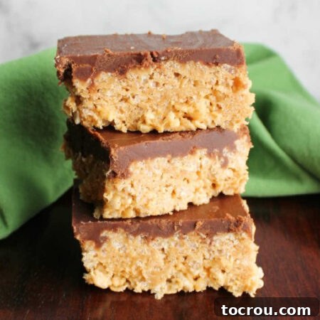 stack of maple peanut butter rice krispie treats with fudge frosting on top.