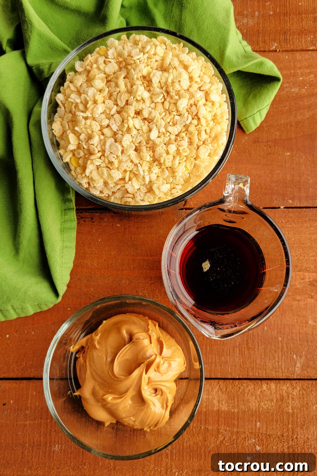 Ingredients for maple peanut butter rice krispie treats laid out: rice krispies cereal, amber maple syrup, and creamy peanut butter.