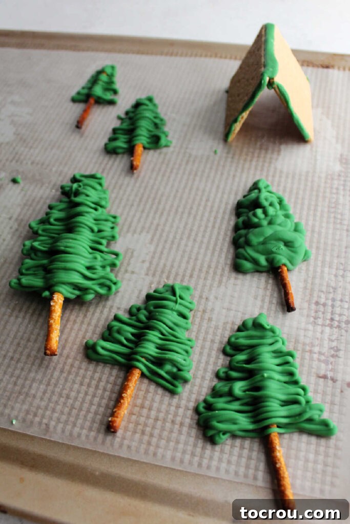 How to Make Pretzel Trees for Cake Step-by-step process of making edible trees for a camping cake using pretzel sticks and melted green chocolate.