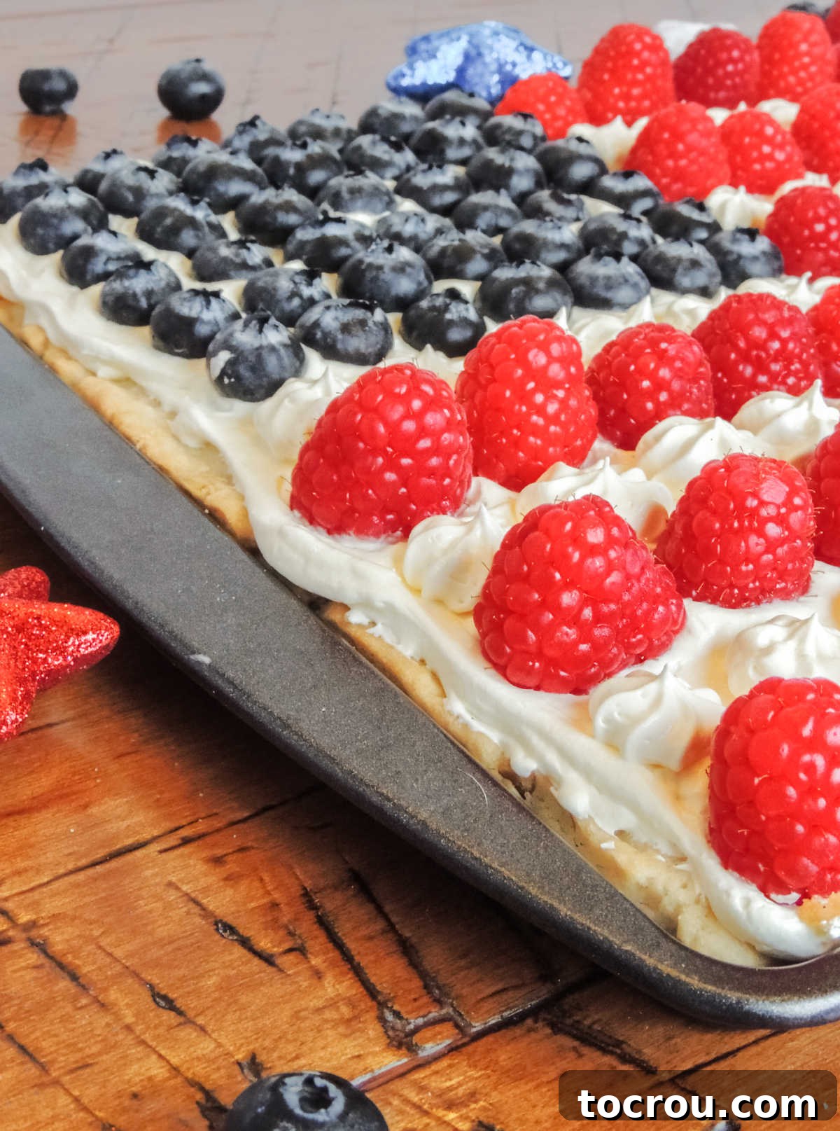 Stars and Stripes Cookie Squares 12 Close up showing rows of raspberries with frosting piped in star shapes between the rows.