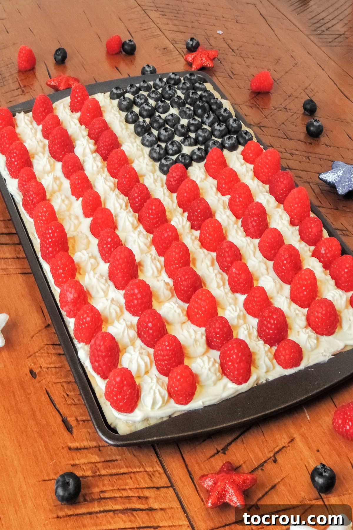 Stars and Stripes Cookie Squares 3 Fruit pizza with raspberries and blueberries designed to look like a flag on top of a sugar cookie crust.