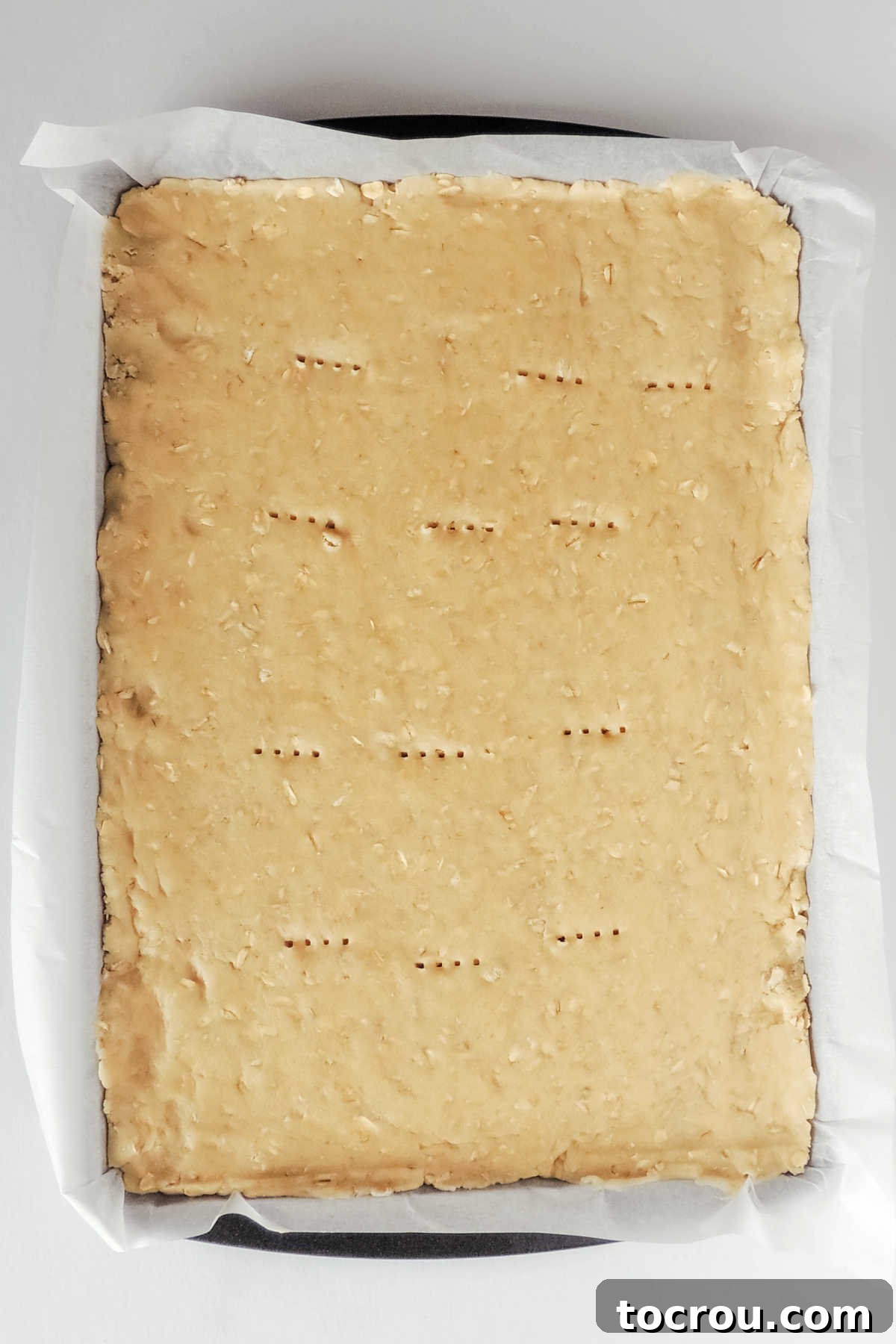 Stars and Stripes Cookie Squares 6 Cookie dough pressed into parchment lined cookie sheet with fork holes pricked into the top.