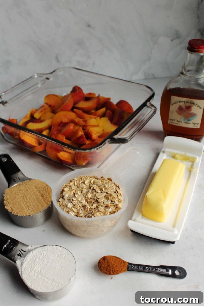 Ingredients laid out on a table, ready to be prepared for making peach crisp, including fresh peaches, oats, flour, brown sugar, and maple syrup.