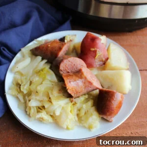 A hearty plate filled with perfectly cooked sausage, tender potatoes, and vibrant cabbage, showcasing a complete and satisfying meal.