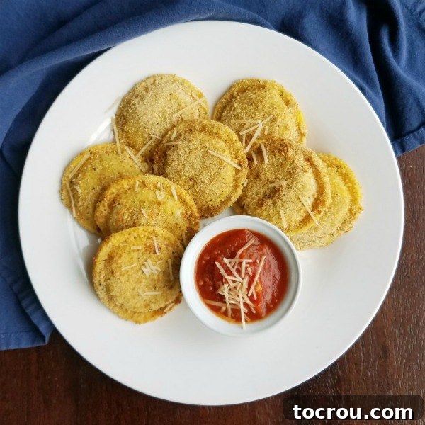 Platter filled with perfectly air-fried toasted ravioli, ready to be enjoyed with a side of tomato sauce.