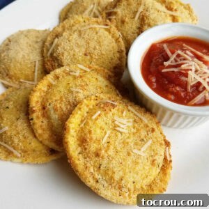 Close up of golden crispy air fryer toasted ravioli served with a ramekin of rich marinara dipping sauce.