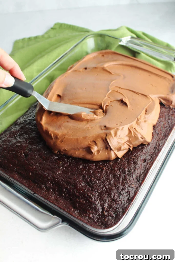 Decadent Chocolate Cream Cheese Frosting 6 Spreading chocolate cream cheese frosting over baked chocolate zucchini cake.