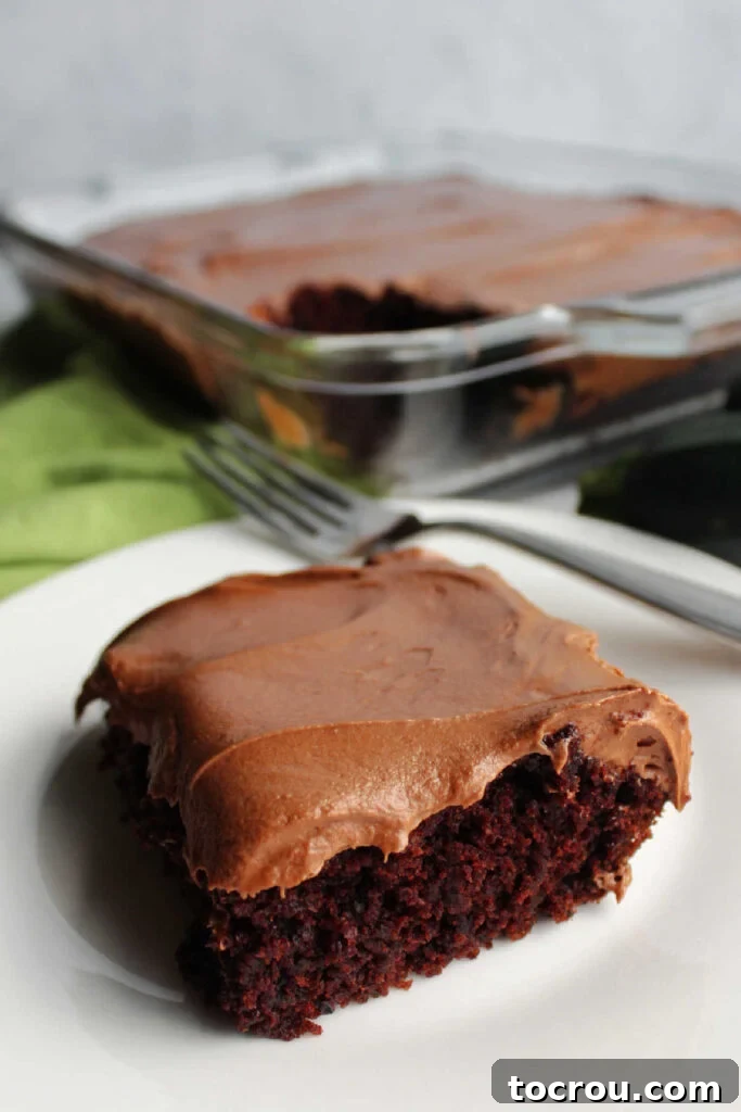 Decadent Chocolate Cream Cheese Frosting 8 Piece of chocolate zucchini cake topped with chocolate cream cheese frosting on cake plate ready to eat.