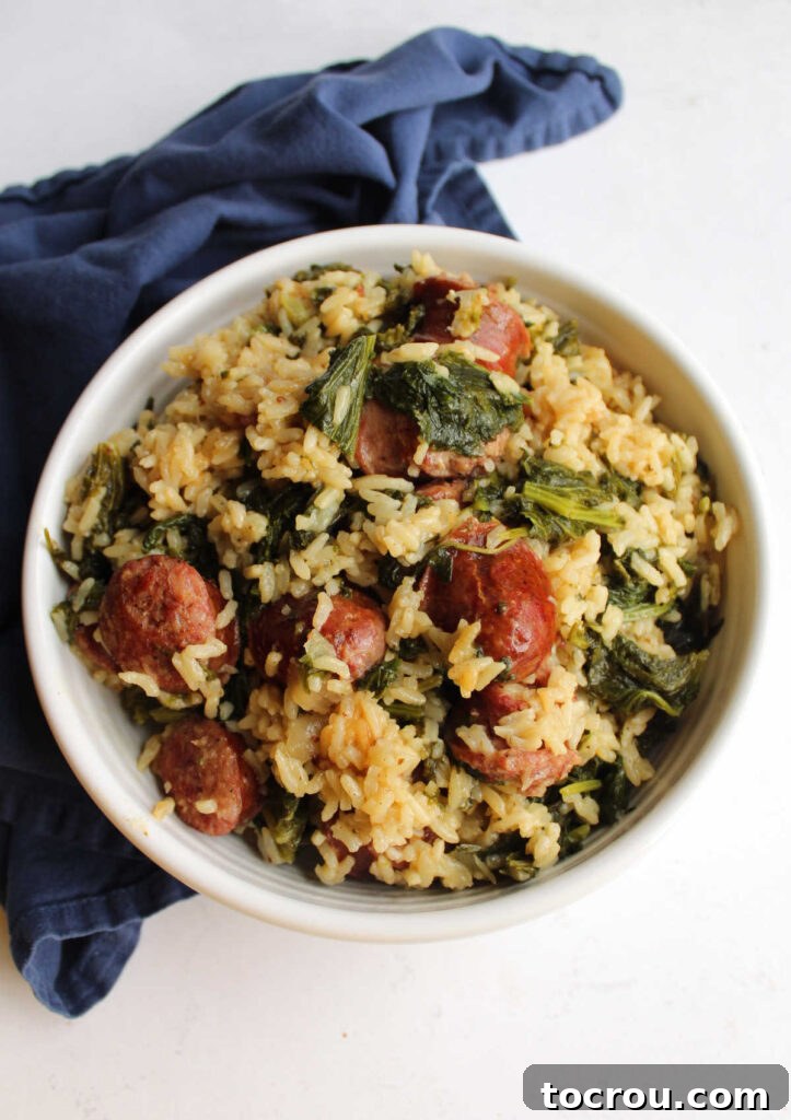A pristine white serving bowl generously filled with a harmonious blend of fluffy rice, succulent slices of Polish sausage (kielbasa), and perfectly wilted mustard greens, creating an inviting and wholesome presentation.
