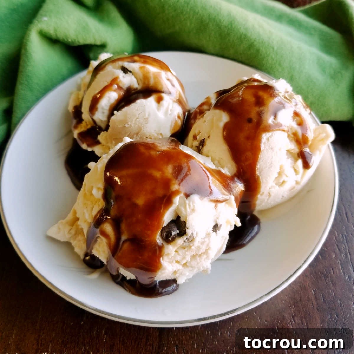 Bowl of peanut butter chocolate chip no churn ice cream topped drizzled with homemade hot fudge sauce. 