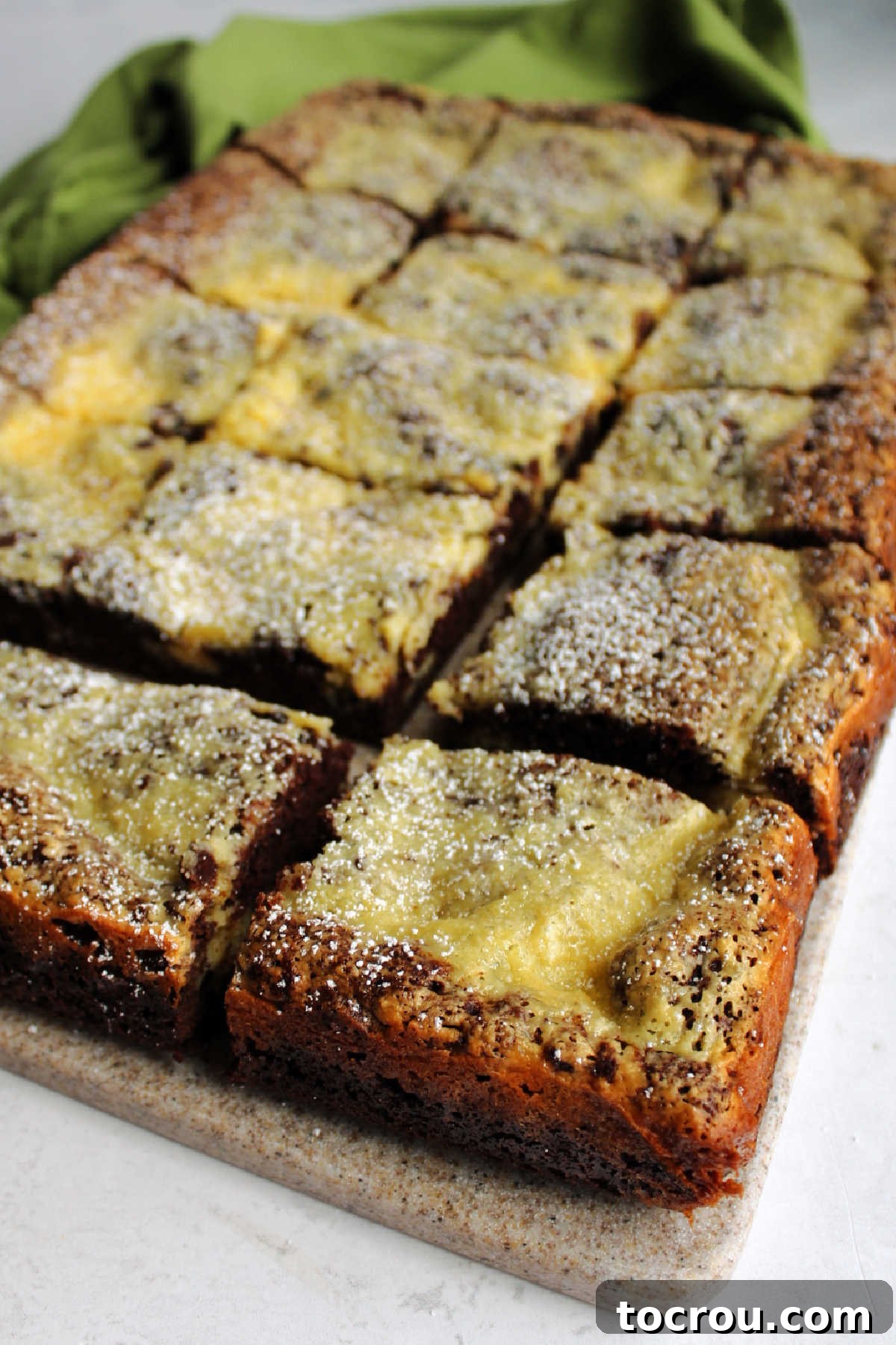 Exquisitely cut slices of Chocolate Chip Gooey Butter Cake artfully arranged, revealing the distinct layers of chocolate crust and its generous, creamy chocolate chip filling.