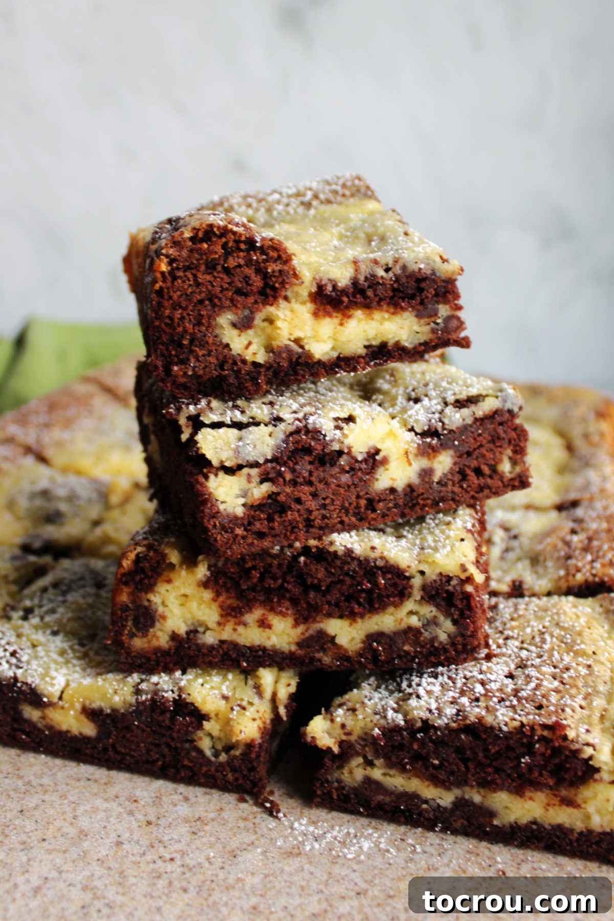 A rustic cutting board laden with an array of freshly baked Chocolate Chip Gooey Butter Cake bars, beautifully arranged and ready to be served and savored.