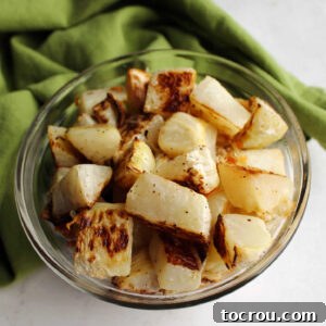 Bowl of roasted chunks of kohlrabi with garlic and Parmesan cheese, showcasing a delicious and easy side dish.