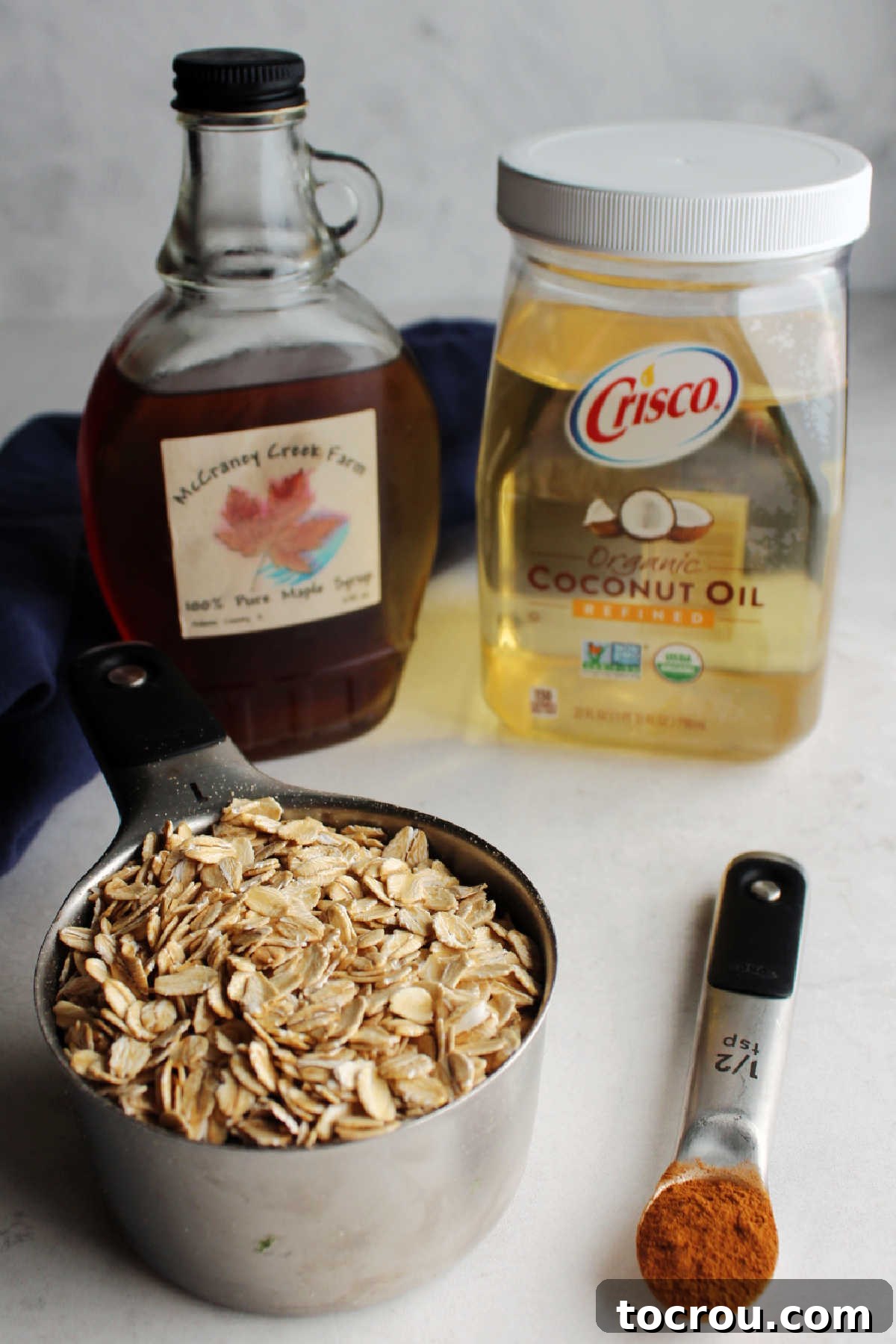 Coconut oil, maple syrup, cinnamon and oats ready to be made into quick and easy granola.