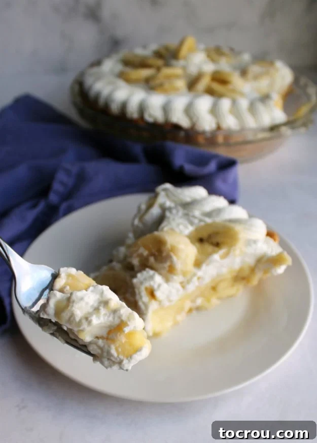 forkful of banana cream pie with homemade custard and fresh whipped cream