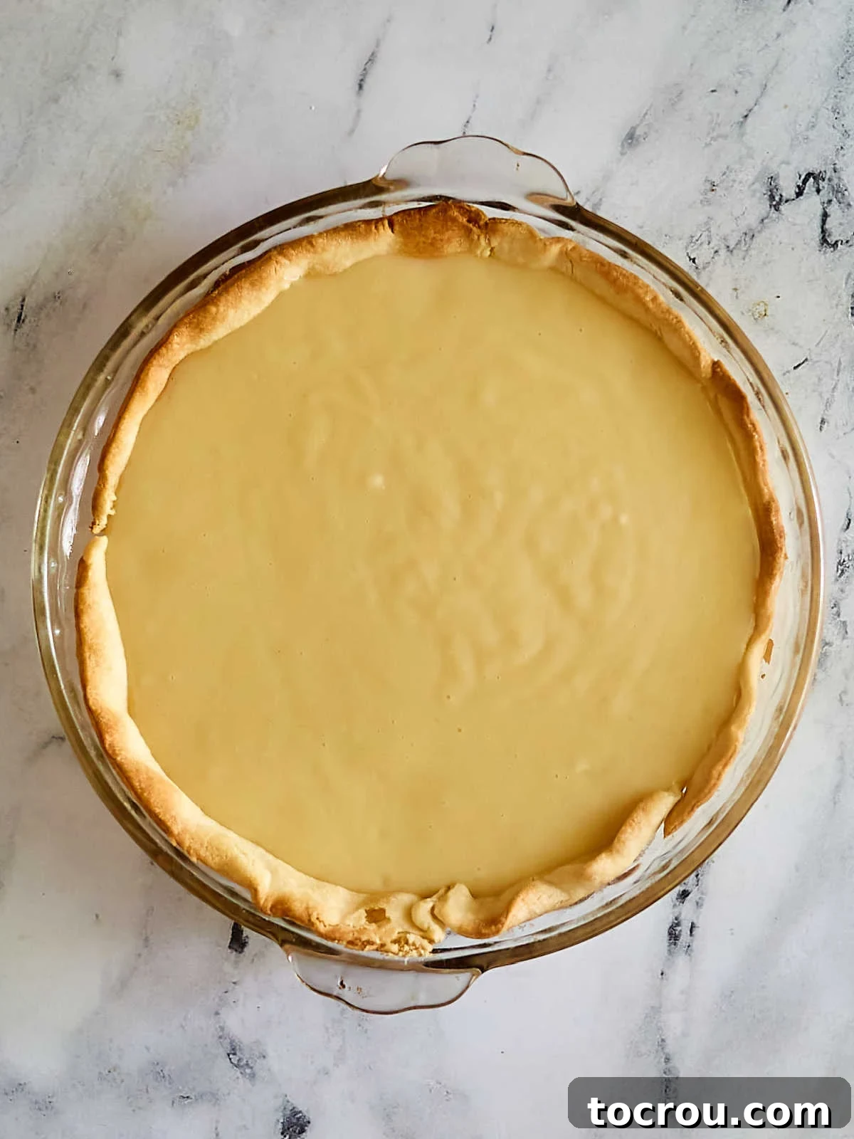 Pie crust with banana sliced covered with pudding mixture, ready to chill.