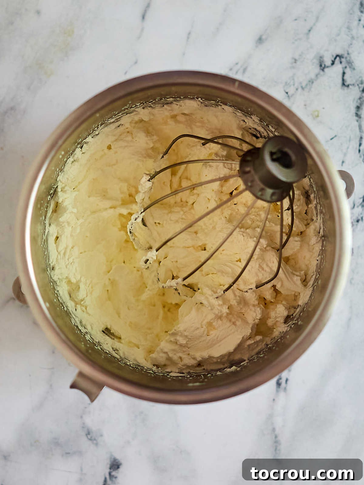 Mixer bowl with whipped cream, ready to go on top of the pie. 