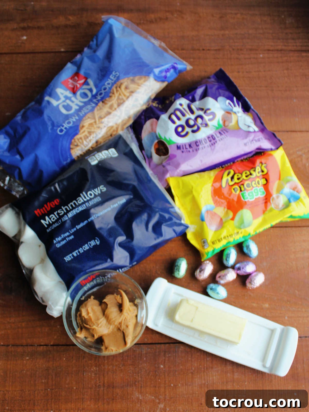 Simple Ingredients for No-Bake Chow Mein Nests All the essential ingredients neatly laid out: crunchy chow mein noodles, soft mini marshmallows, rich butter, creamy peanut butter, and festive candy eggs, ready to be transformed into edible nests.