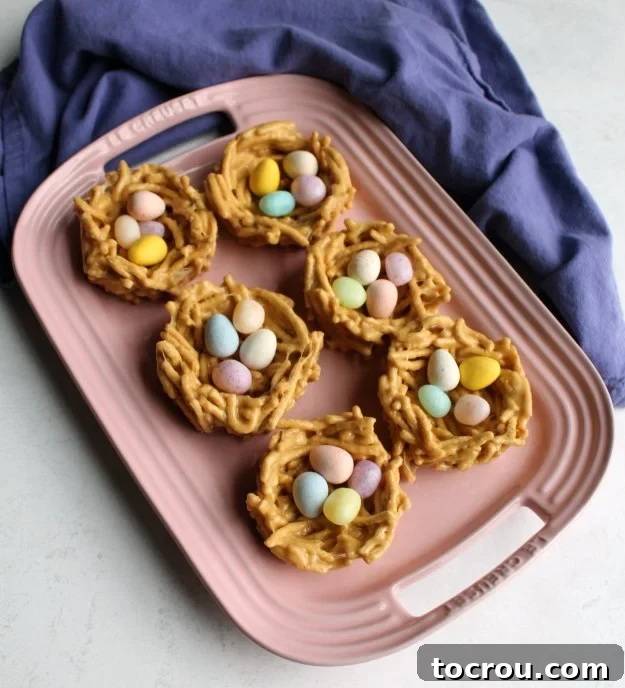 Cute Edible Chow Mein Nests for Spring & Easter A beautiful close-up of finished, candy-filled chow mein nests arranged on a light background, highlighting their charming appearance and delicious filling. The image emphasizes that these are easy, no-bake treats, ideal for celebrating spring or Easter.