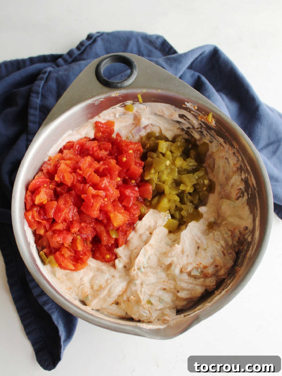 Fiesta Cream Dream 6 Stirring rotel and chopped green chiles into dip.