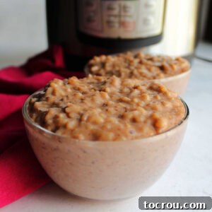 Two small glass bowls filled with creamy chocolate rice pudding in front of pressure cooker.