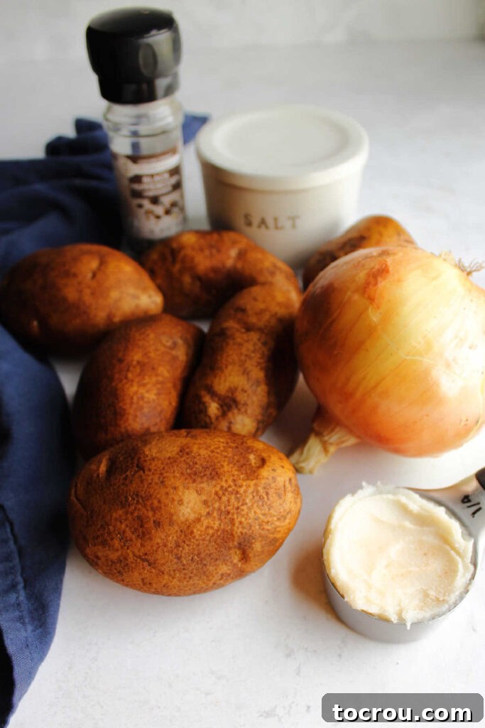 Peeled and sliced potatoes, finely diced onion, and basic seasonings like salt and pepper, arranged on a surface in preparation for frying.