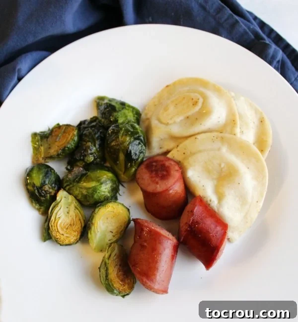 Ready-to-Eat Dinner Dinner plate of sheet pan meal with sausage, pierogies and brussels sprouts, ready to eat.
