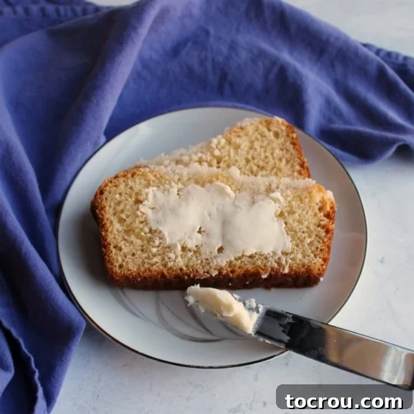 Delicious Placek with a light smear of butter, a simple yet perfect accompaniment. A slice of buttery crumb-topped Placek bread, lightly spread with butter, highlighting its moist interior.