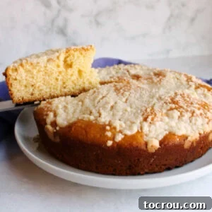 First slice of crumb-topped Placek being lifted out of round cake-like loaf