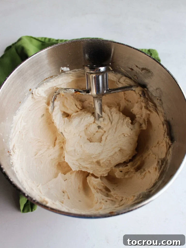 Mixing bowl filled with apple butter buttercream frosting and paddle attachment.