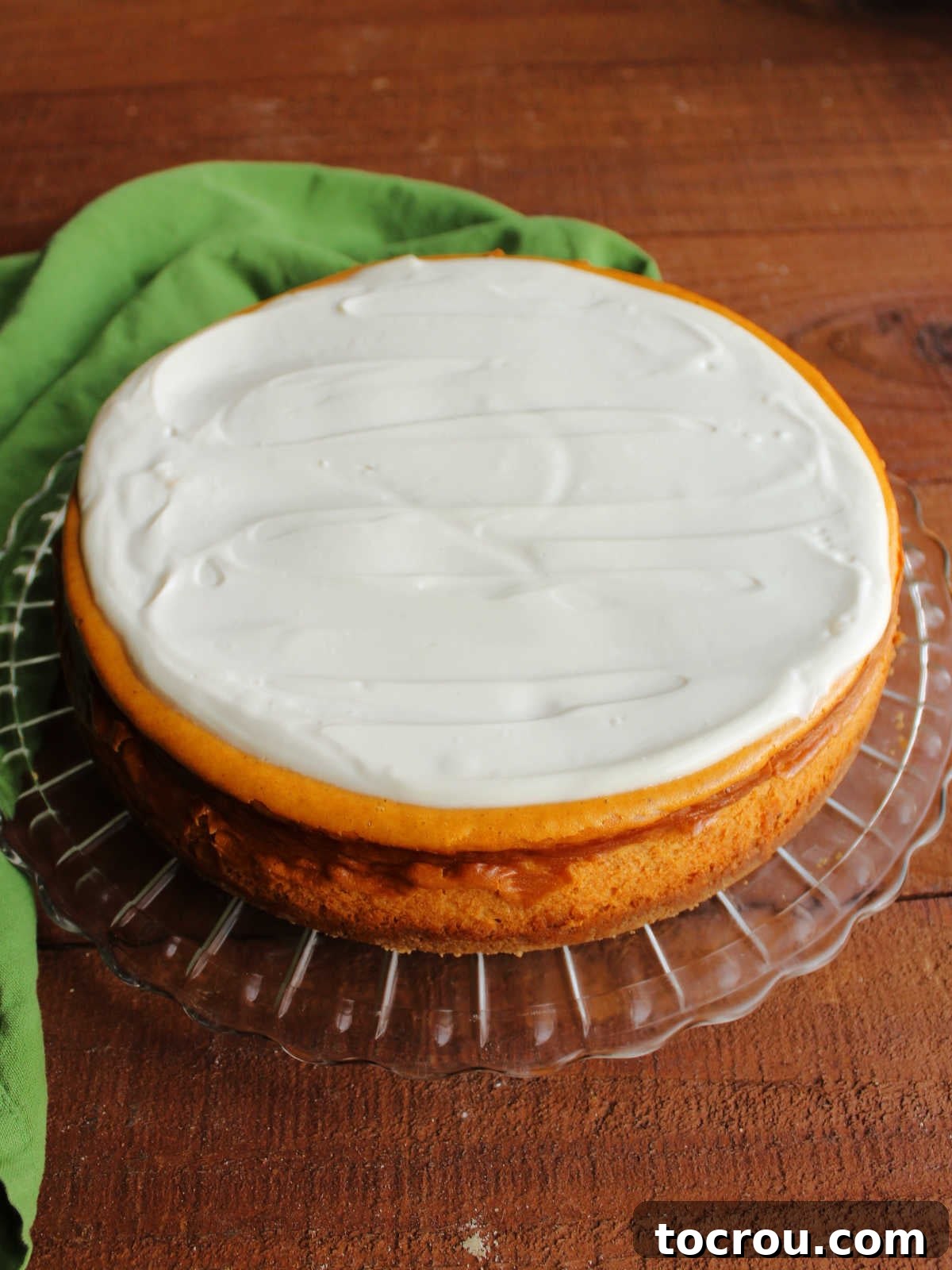 Decadent Pumpkin Cheesecake 8 Whole pumpkin cheesecake with sour cream topping spread over the top.