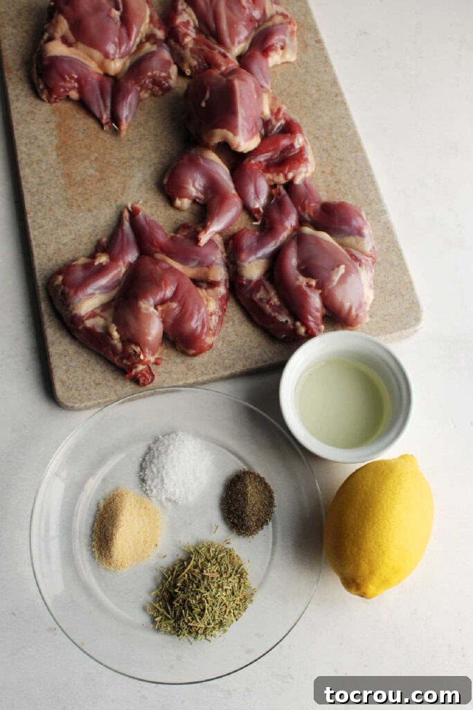 Marinade Ingredients Collection of fresh ingredients for roasted quail: whole quail, a vibrant lemon, cooking oil, fresh rosemary, garlic powder, salt, and black pepper arranged beautifully.