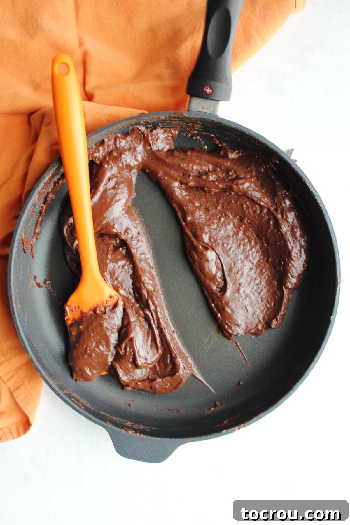 Zesty Chocolate Brigadeiro 5 The cooked chocolate brigadeiro filling in a skillet, showing its thick consistency where a spatula has left a clear trail, indicating it's ready.