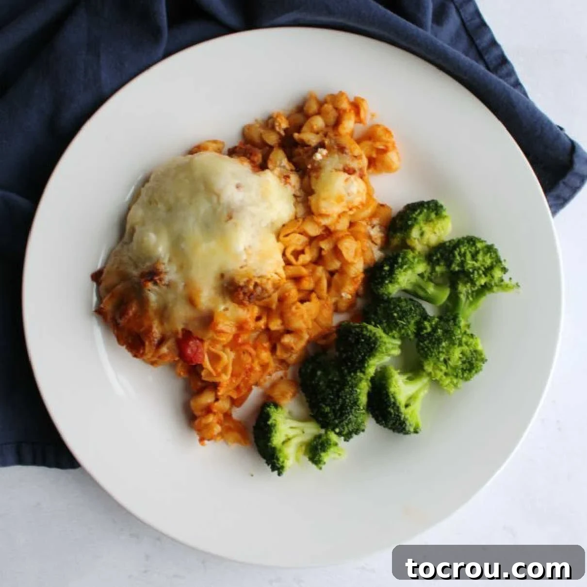 Effortless No-Boil Cheesy Italian Sausage Pasta Bake: Your New Weeknight Hero! dinner plate with baked Italian style pasta casserole and broccoli.