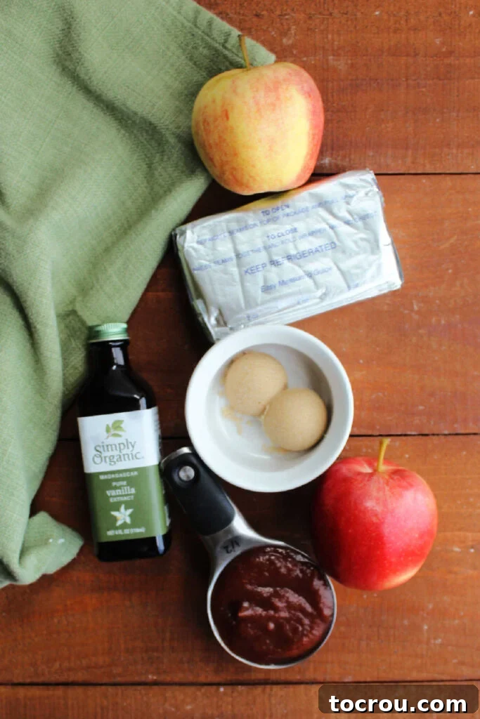 Four simple ingredients for creamy apple butter dip laid out: cream cheese, brown sugar, apple butter, and vanilla extract.