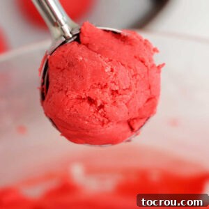 Small scoop of red velvet truffle mixture, demonstrating the ideal portion size before rolling.