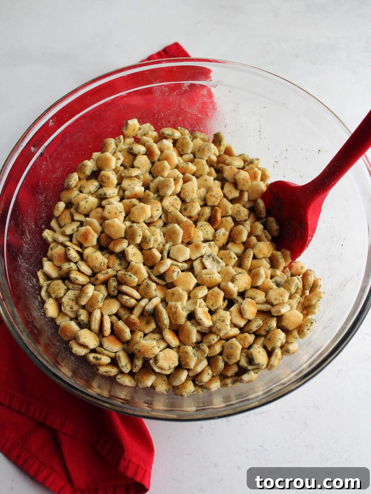 Bowl of soup crackers tossed in oil and seasonings.