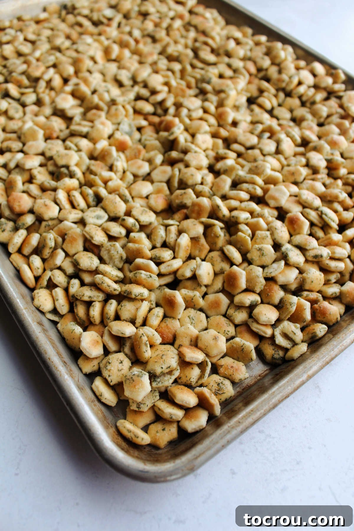 Baked ranch soup crackers on rimmed cookie sheet, ready to cool.