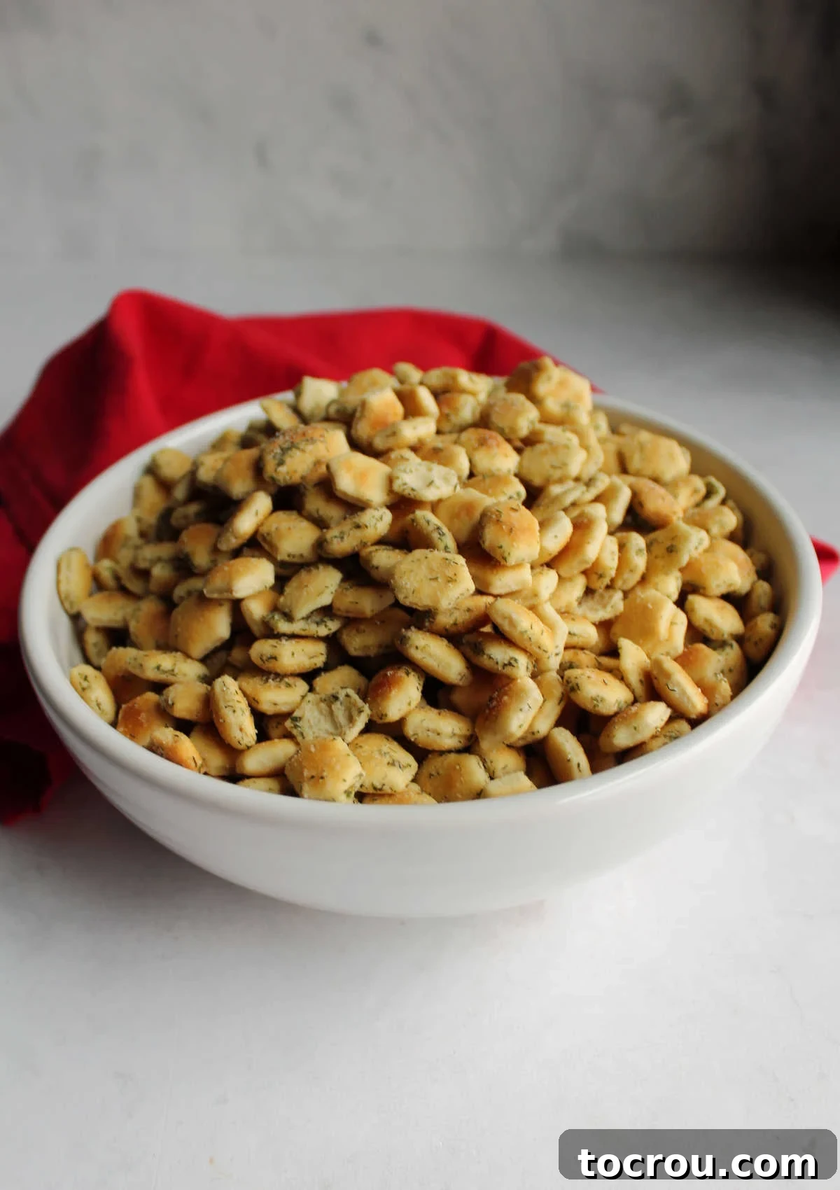 White serving bowl filled with ranch oyster crackers, ready to eat.