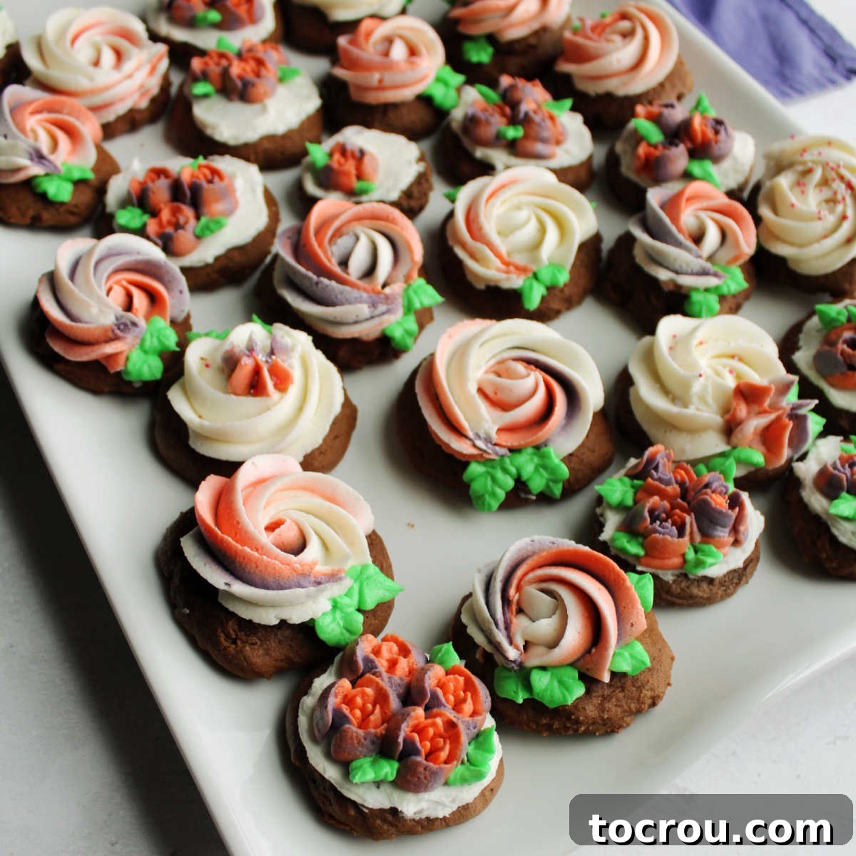 Velvet Chocolate Sour Cream Treats 2 Platter of round chocolate sour cream cookies topped with buttercream rosettes and flowers.