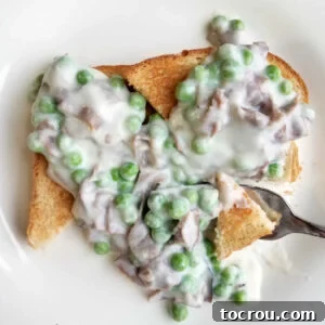 Toast covered with creamed chipped beef and peas.