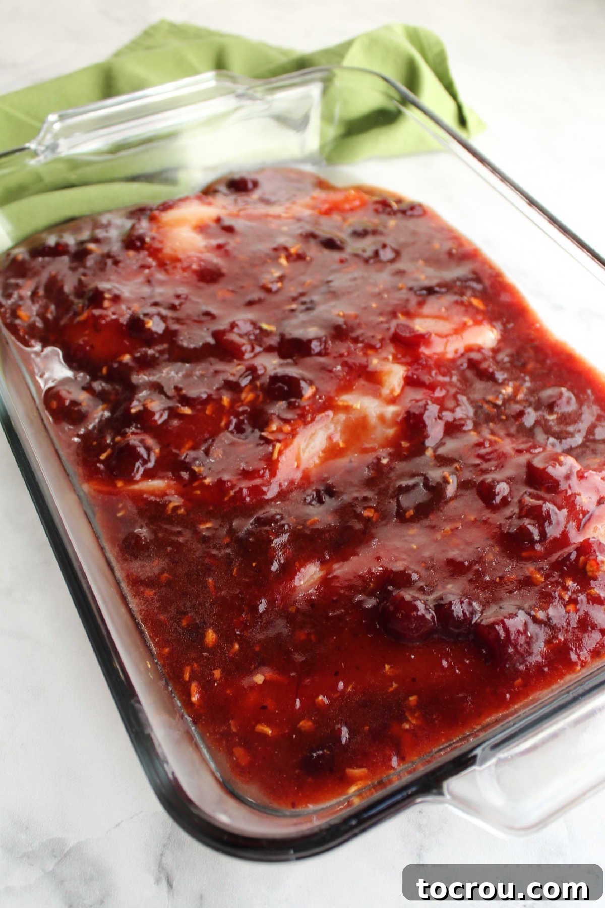 Pan of chicken and cranberry sauce ready to go in the oven.